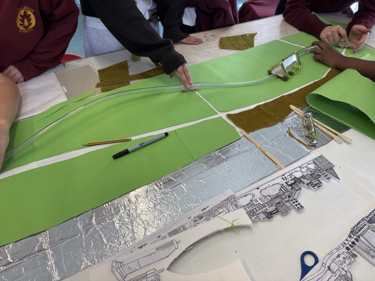 Year 6 children experimenting with ways to reinforce the monorail for the city model.